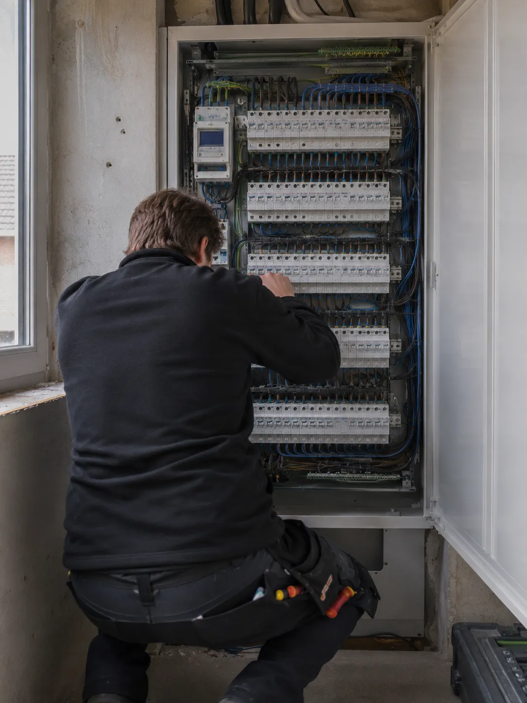 Elektriker arbeitet am Schaltschrank im Einfamilienhaus